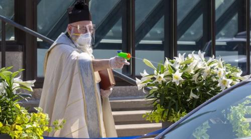 Un preot din Detroit a devenit viral după ce a folosit un pistol de jucărie pentru a binecuvânta cu apă sfințită credincioșii