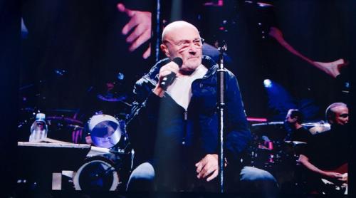 Phil Collins, bolnav, cântă așezat într-un scaun pe scenă: „Abia mai pot să țin un băț în mână”