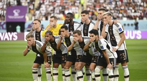 Jucătorii Germaniei pozează cu mâna la gură pentru a protesta împotriva interzicerii banderolei curcubeu